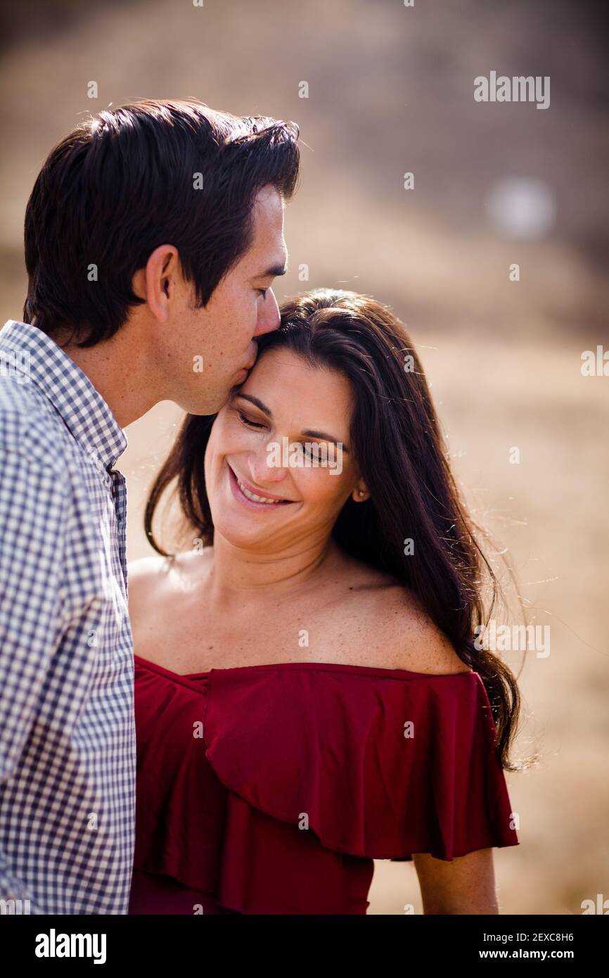 Primo piano di marito Kissing moglie in attesa a San Diego Foto Stock