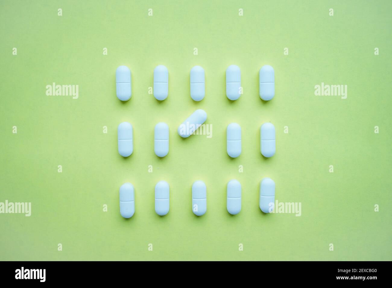 Pillole di bianco su uno sfondo verde chiaro Foto Stock