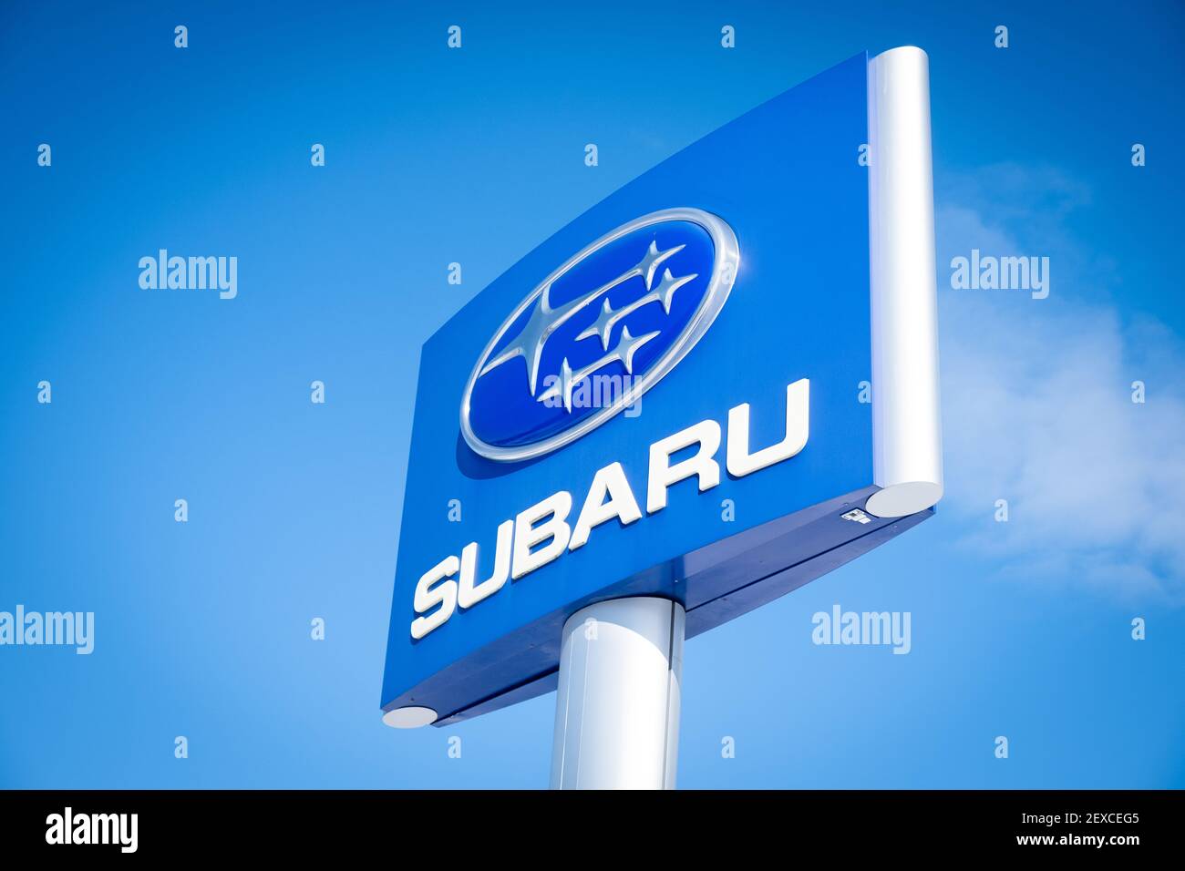 Bella foto drammatica e luminosa del logo aziendale Subaru contro cielo blu luminoso, Twin City Subaru, Berlino, VT, USA. Foto Stock