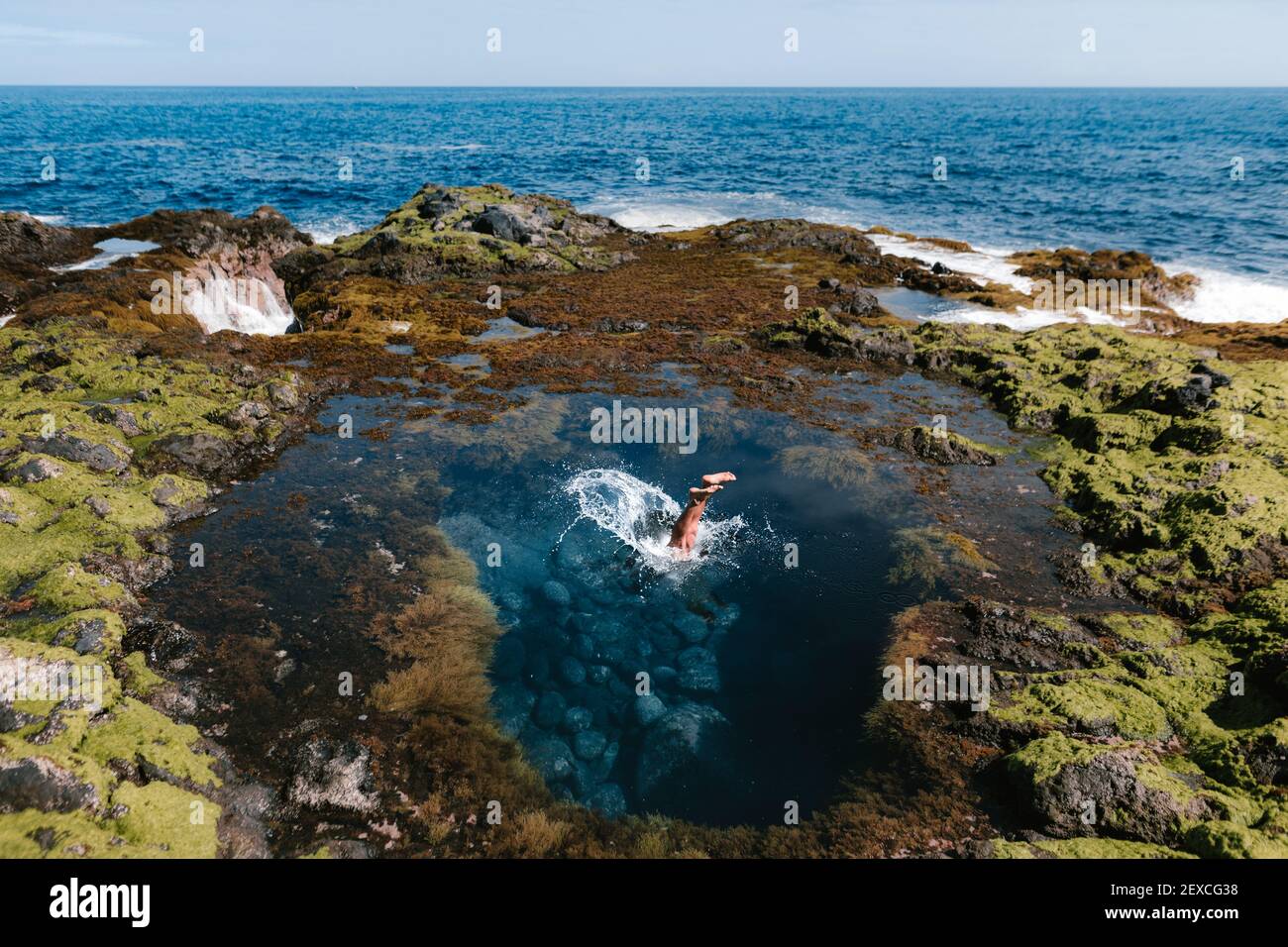 Gambe di una persona che salta in mare su un estate da Foto Stock