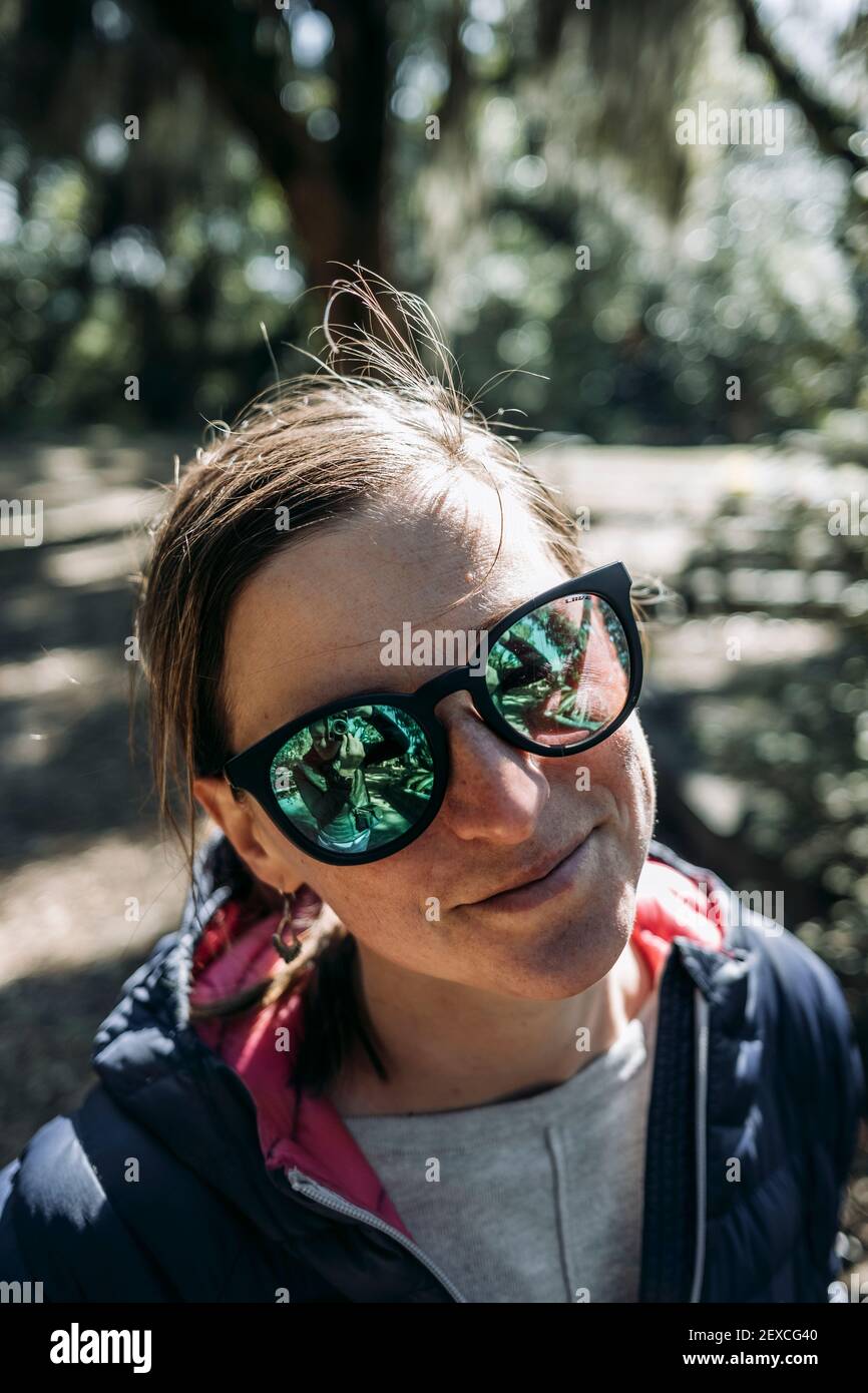 Ritratto di donna caucasica sorridente con occhiali da sole verdi a specchio Foto stock Alamy