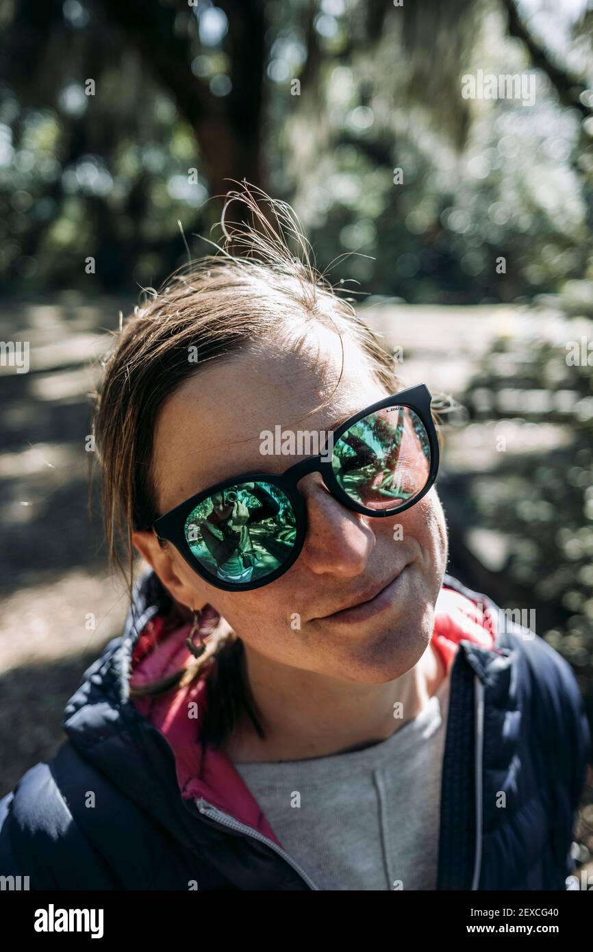 Ritratto di donna caucasica sorridente con occhiali da sole verdi a  specchio Foto stock - Alamy