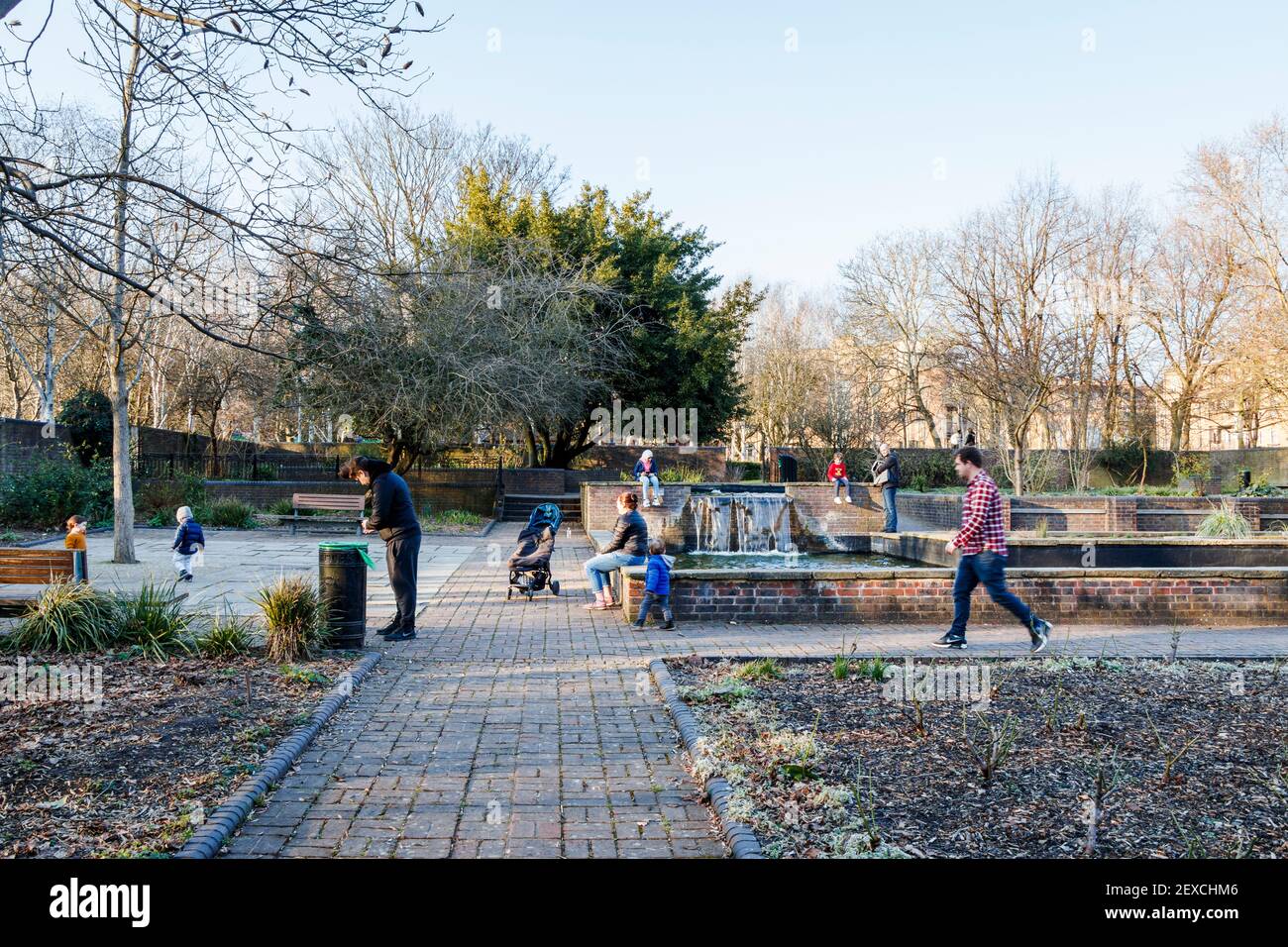Genitori e bambini nel Giardino della Pace di Elthorne Park in un pomeriggio invernale durante il terzo blocco del coronavirus, Islington, Londra, Regno Unito Foto Stock