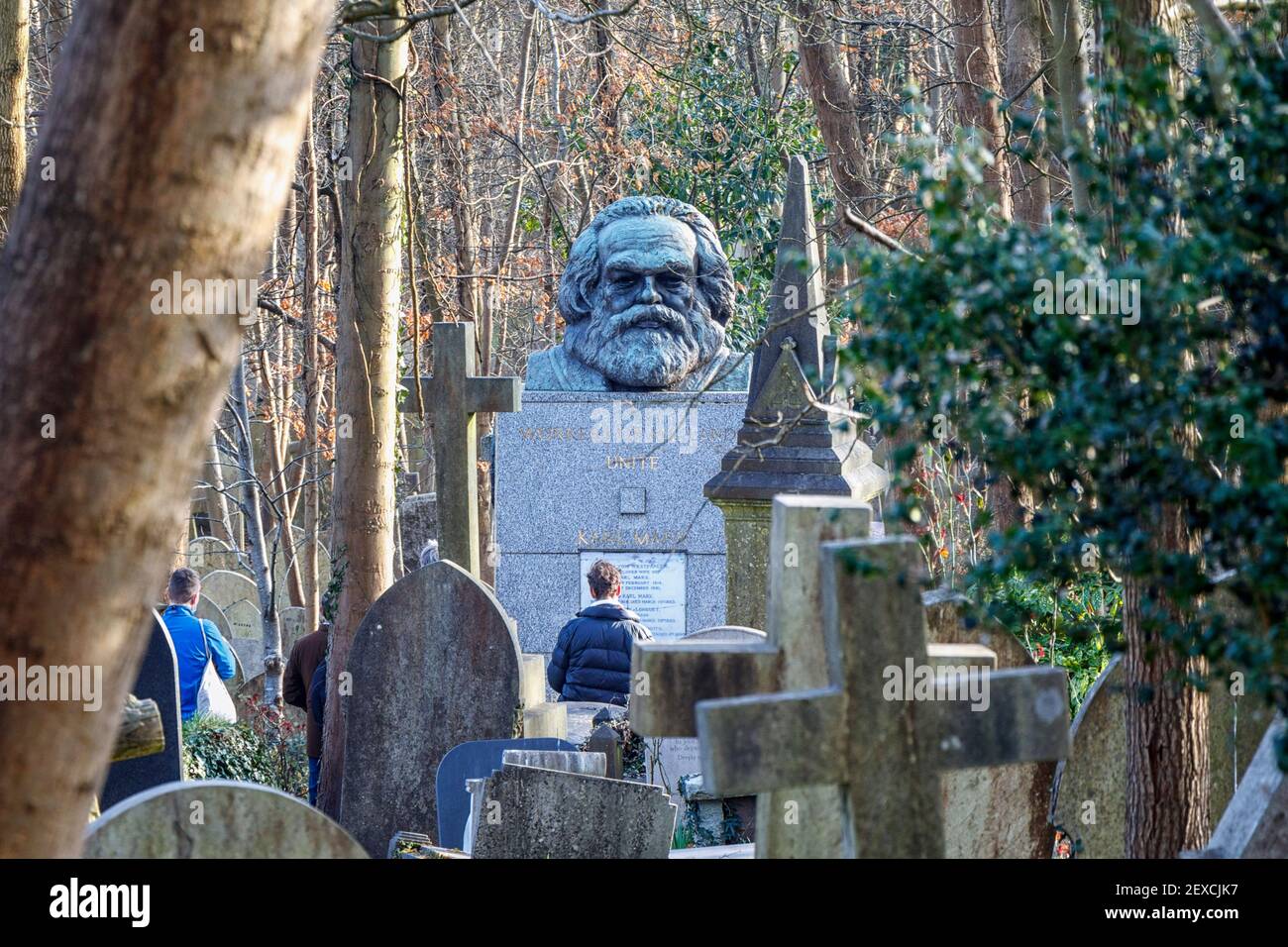 Turisti che visitano la tomba di Karl Marx nel cimitero di Highgate, visto dall'adiacente Waterlow Park, Londra, Regno Unito Foto Stock