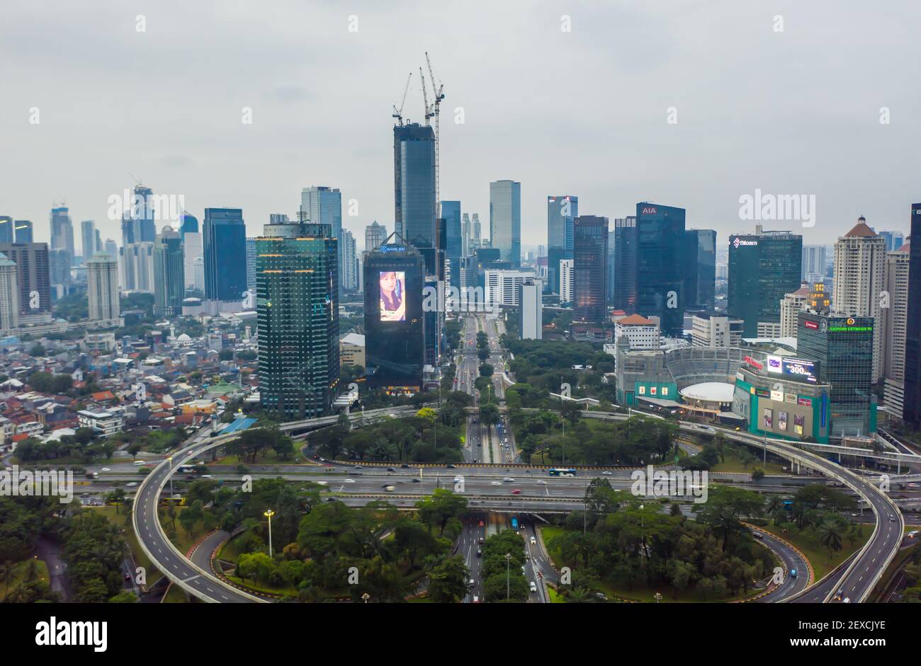 Ampia vista aerea di alti grattacieli e grande traffico rotatoria nel centro urbano di Giacarta, uffici Indonesia e edifici residenziali nel centro della città Foto Stock