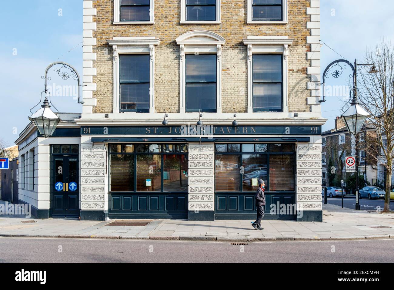 Un uomo cammina oltre la St. John's Tavern, un popolare pub locale ad Archway, Islington, durante il terzo blocco del coronavirus, Londra, Regno Unito Foto Stock