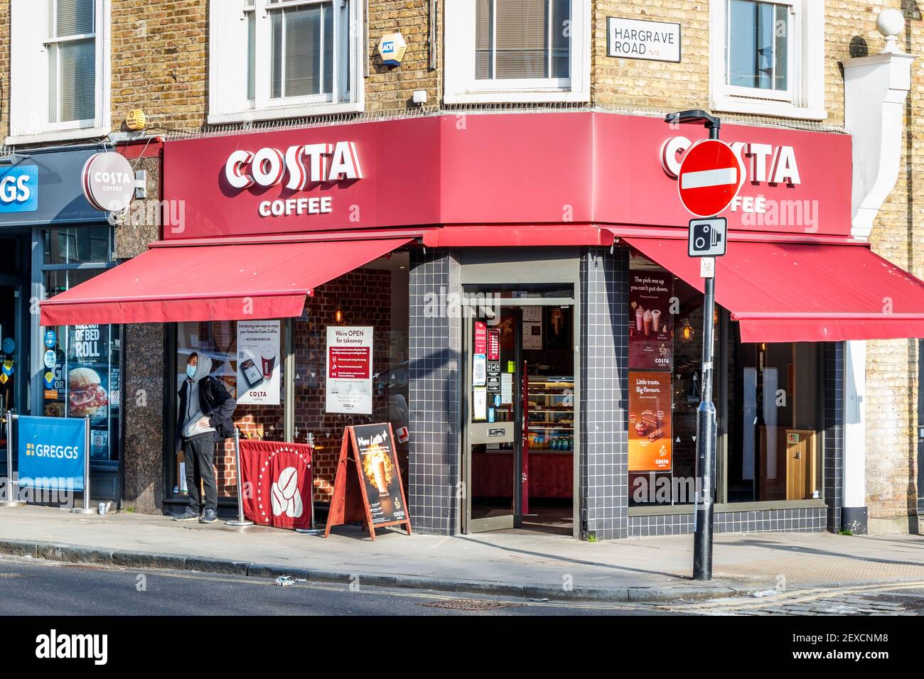 Un uomo attende fuori da un ramo di Costa Coffee, aperto per il take-away solo nel terzo lockdown coronavirus, Islington, Londra, UK Foto Stock