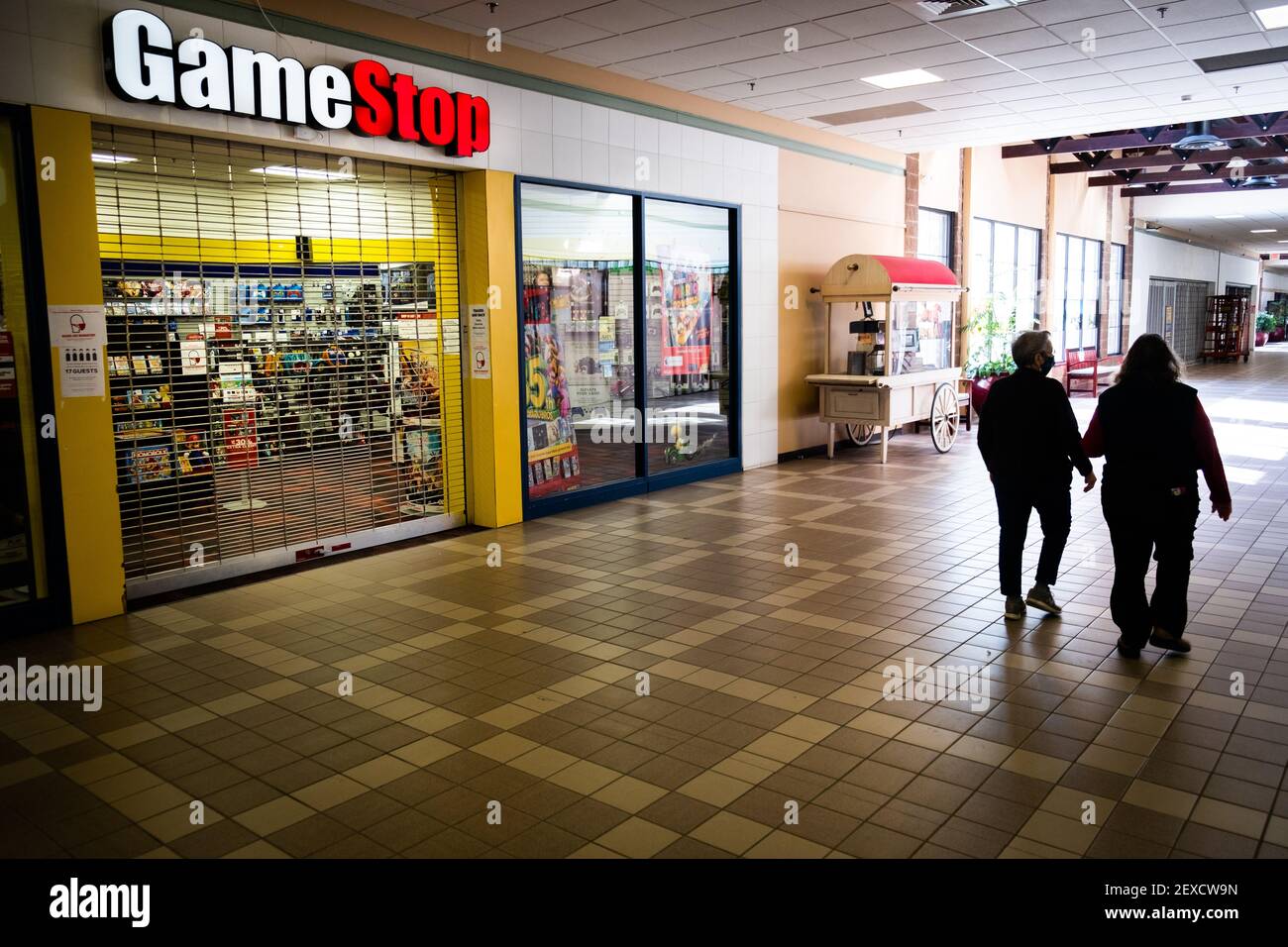 Gli escursionisti del centro commerciale si fermeranno davanti a un negozio chiuso e desertato Game Stop nel Berlin Mall, Berlin, VT, USA. Foto Stock