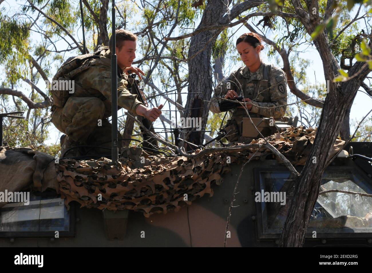 Un soldato americano assegnato al 2 ° Battaglione, 27 ° reggimento di campo, 3 ° Brigade Combat Team, 25 ° Divisione di fanteria, e un membro con la 7 ° Brigata australiana ha istituito un'antenna satellitare durante l'esercizio Talisman Saber 2015 a Shoalwater Bay Training Area in Queensland, Australia, 14 luglio 2015. Talisman Sabre è un esercizio biennale combinato tra le milizie statunitensi e australiane, progettato per migliorare sia la capacità di nationsâ€™ di rispondere alle contingenze regionali. (Foto di Sgt. Brian C. Erickson/USA Army) *** si prega di utilizzare credito da campo di credito *** Foto Stock