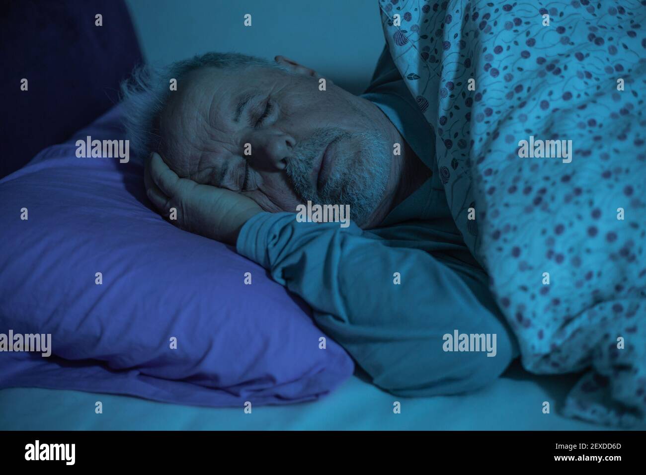 Dormendo l'uomo anziano nel letto durante la mezzanotte, concetto di stile di vita Foto Stock