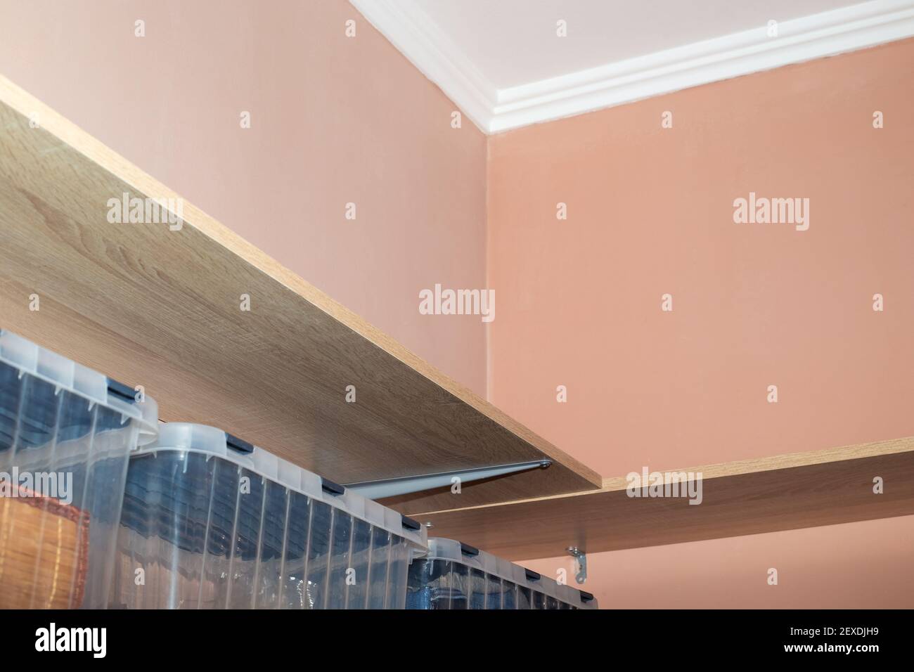 Scaffali in legno, ripostiglio nel spogliatoio con pareti beige. Foto Stock