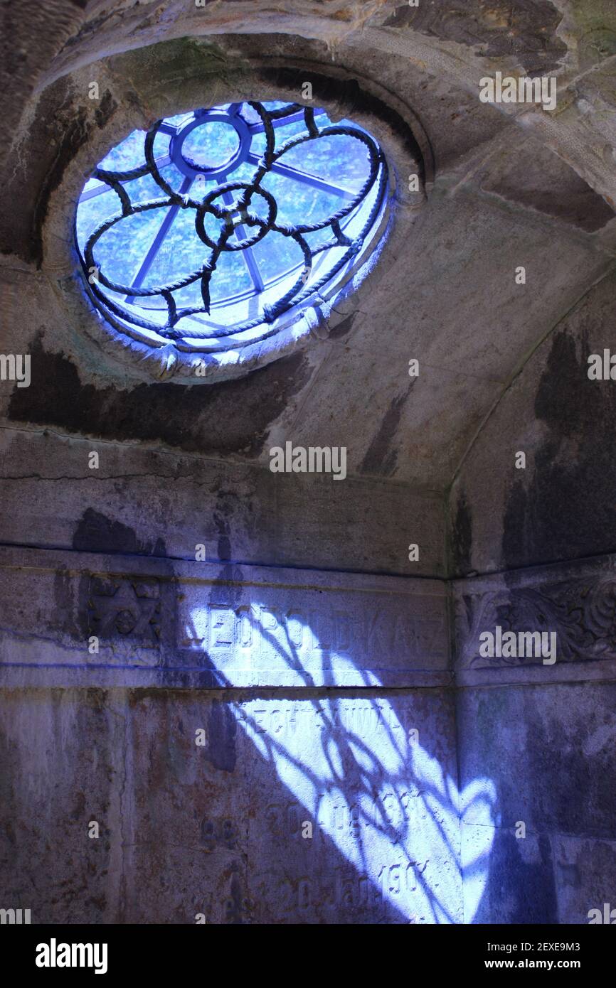 Finestra di vetro blu in una tomba sul cimitero ebraico di Berlino Weissensee in una giornata di sole Foto Stock