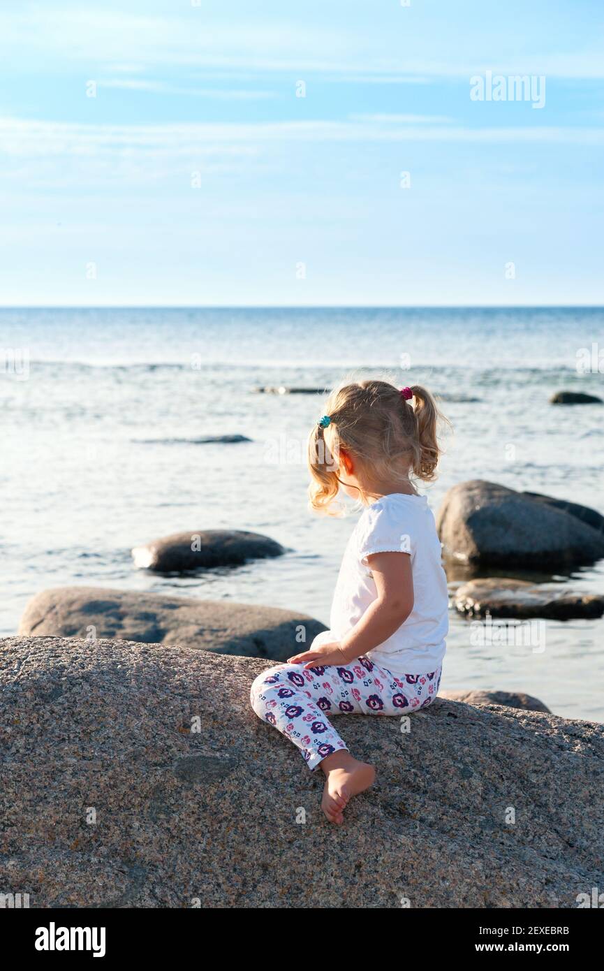 Bambina che guarda al mare Foto stock - Alamy