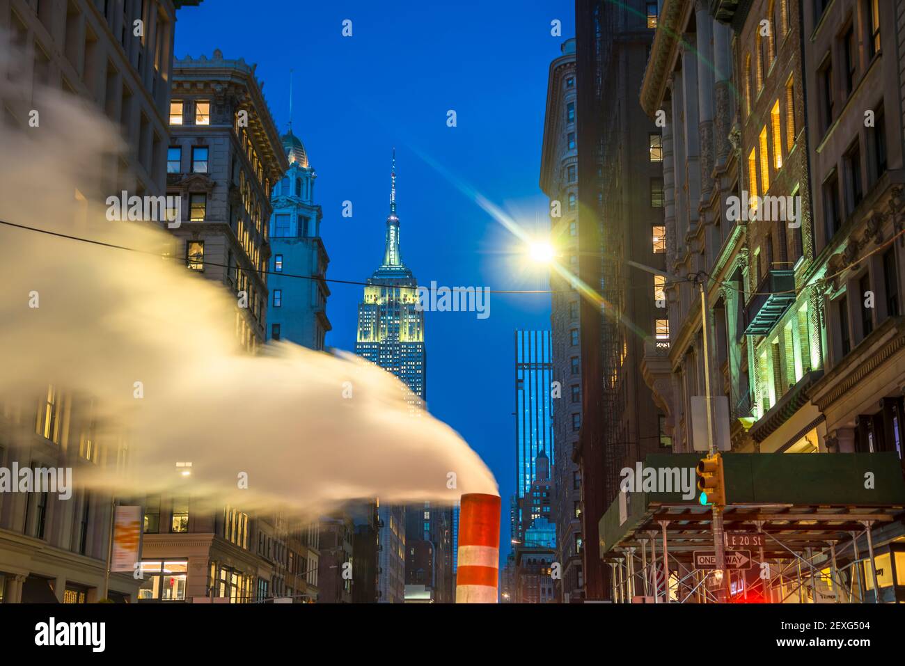 L'Empire state Building si illumina tra gli edifici del centro di Manhattan durante le festività natalizie a New York City. Foto Stock