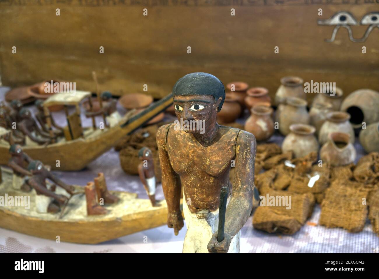 Museo Egizio di Torino - Febbraio 2021: Statuetta lignea umanoide e altri reperti in una sepoltura tradizionale Foto Stock