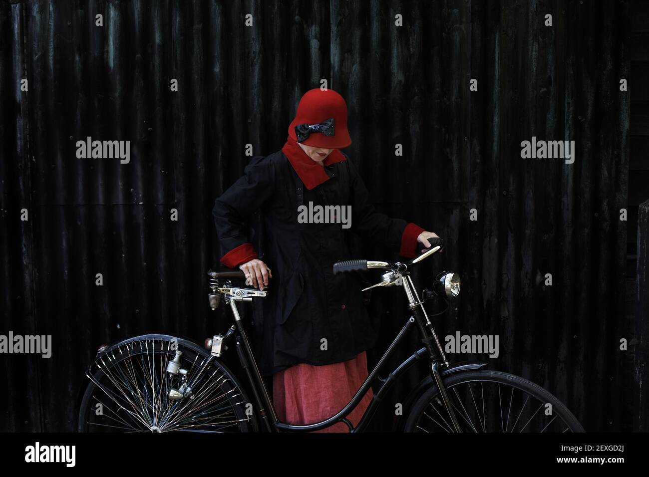 donna in un abito d'epoca retrò in posa con bicicletta classica Foto Stock