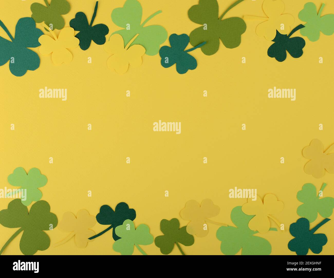 St Patricks Day doppio bordo di sciamrocce di carta fatte a mano su sfondo giallo. Disposizione piatta. Vista dall'alto. Spazio di copia. Foto Stock