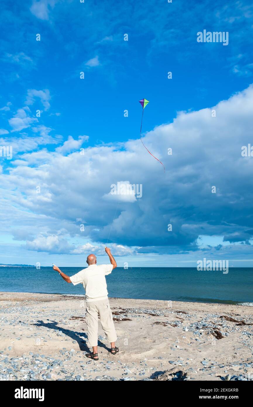 Volare un aquilone sulla spiaggia Foto Stock