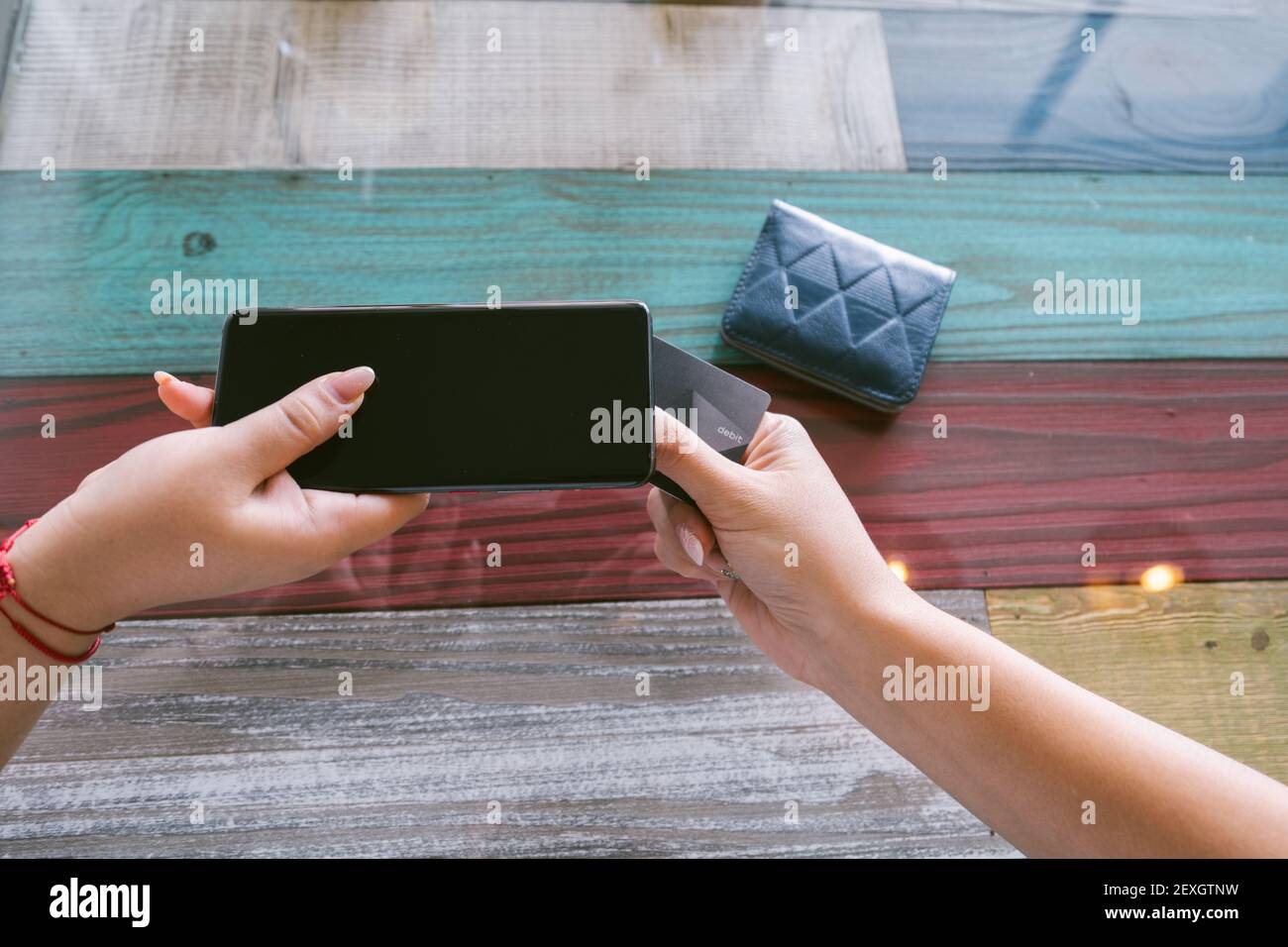 Meno contatti utilizzando lo smartphone con una carta di debito per il pagamento NFC Foto Stock
