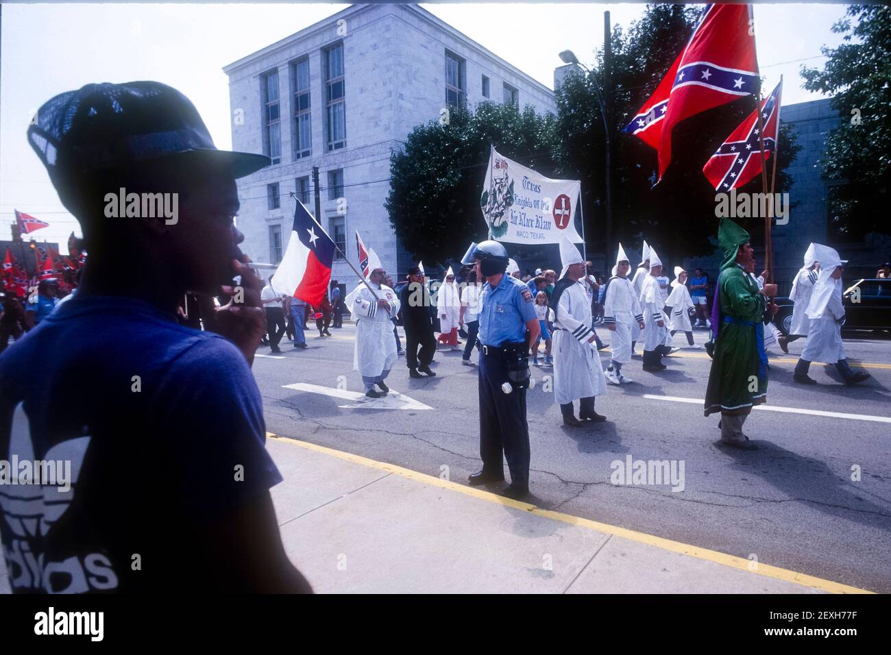 Gainesville, Georgia, Stati Uniti. 10 gennaio 2019. Un residente locale guarda come membro del Waco, Texas Knights of the Ku Klux Klan marciare attraverso il centro in una protesta contro i diritti civili. C. 1987 (immagine di credito: © Robin RayneZUMA Wire) Foto Stock