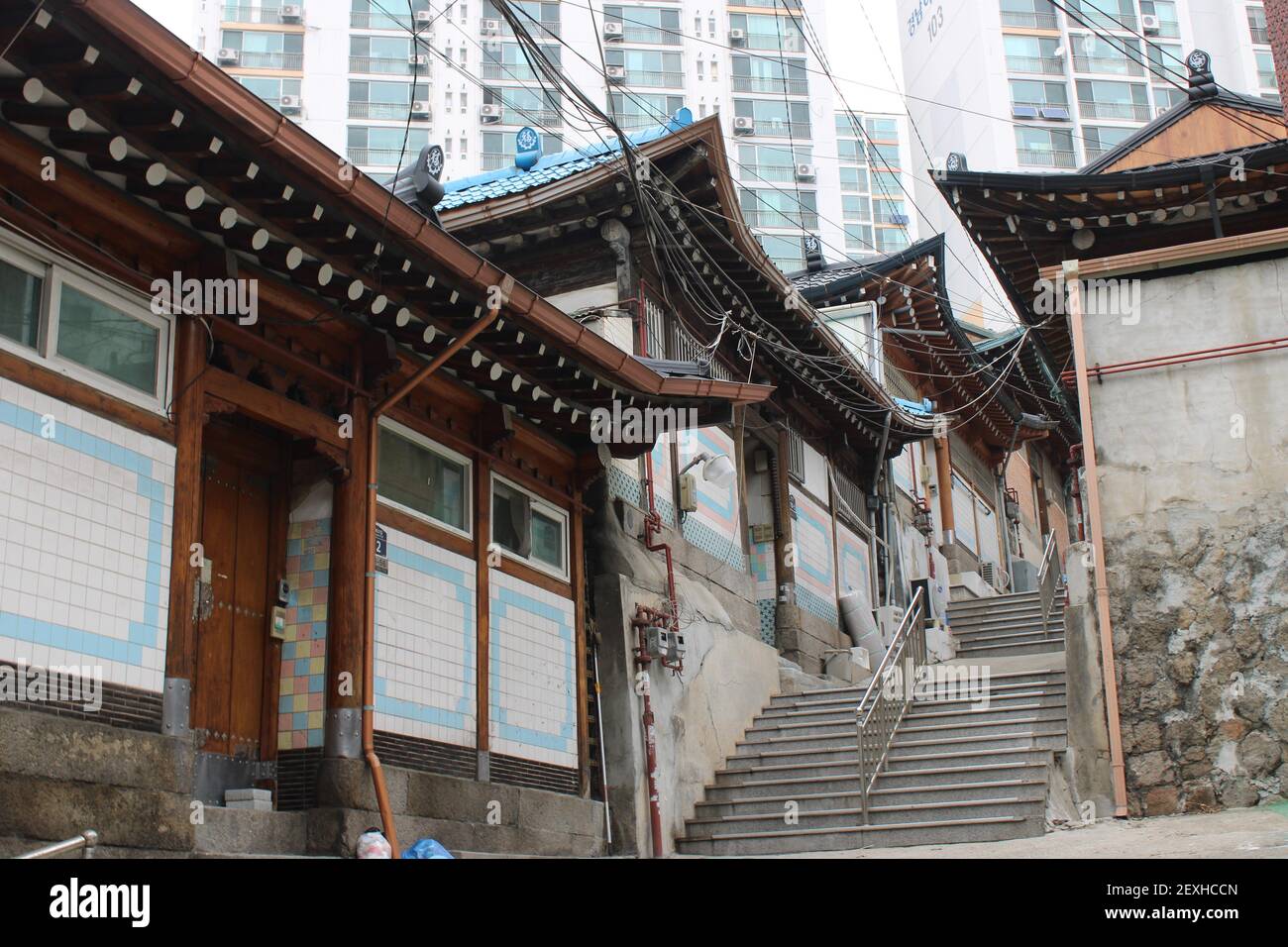 Tradizionali case asiatiche che costeggiano una scalinata che conduce a un moderno condominio edifici Foto Stock