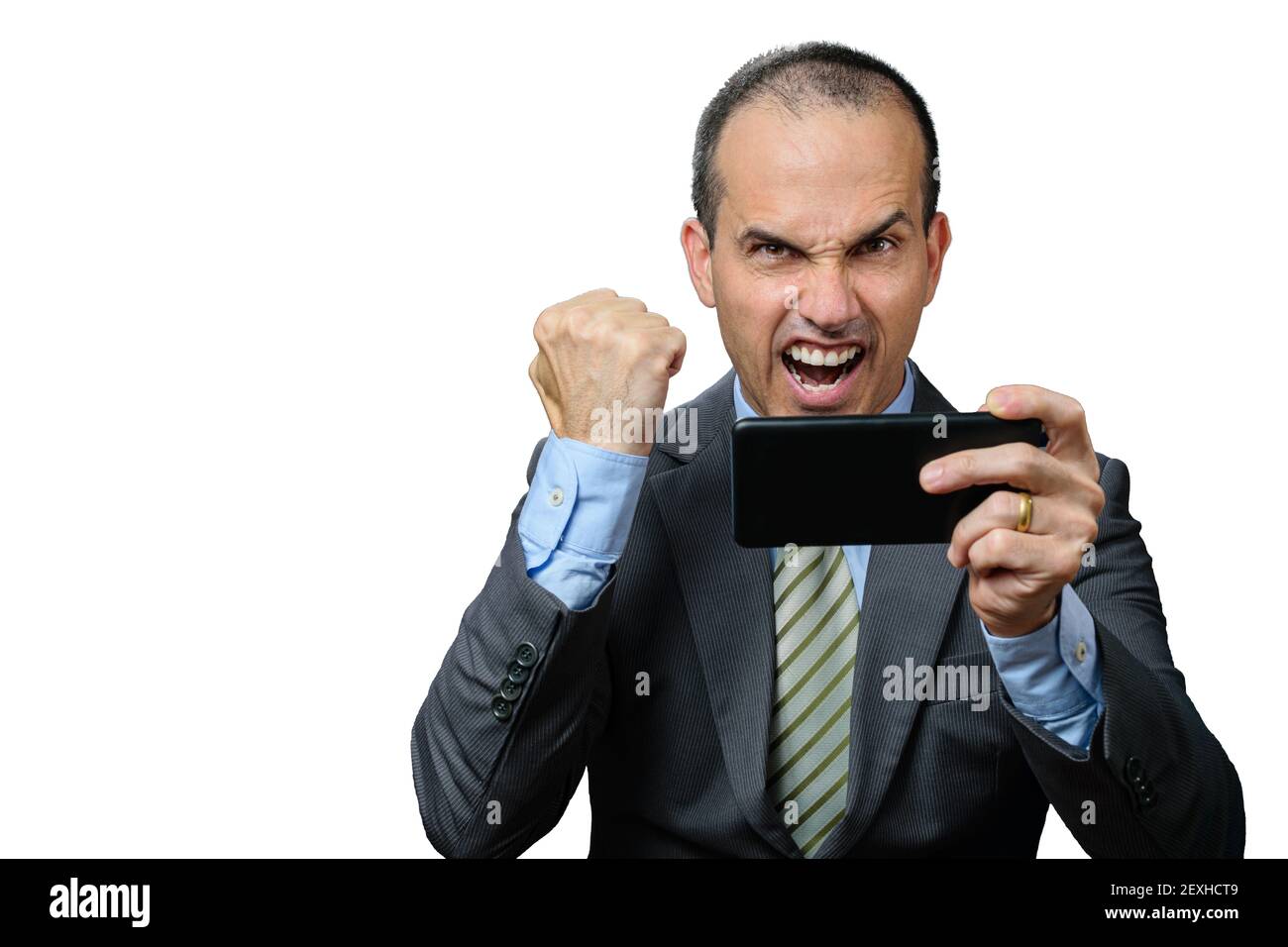 Uomo maturo con abito e cravatta, tenendo il suo smartphone orizzontalmente e festeggiando con un pugno chiuso. Foto Stock