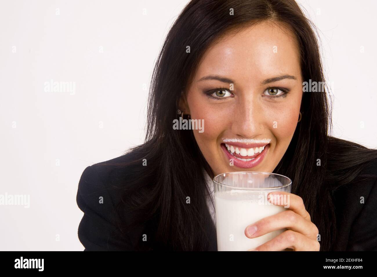 Bella Brunette femmina bevande e ottiene un baffi latte Foto Stock