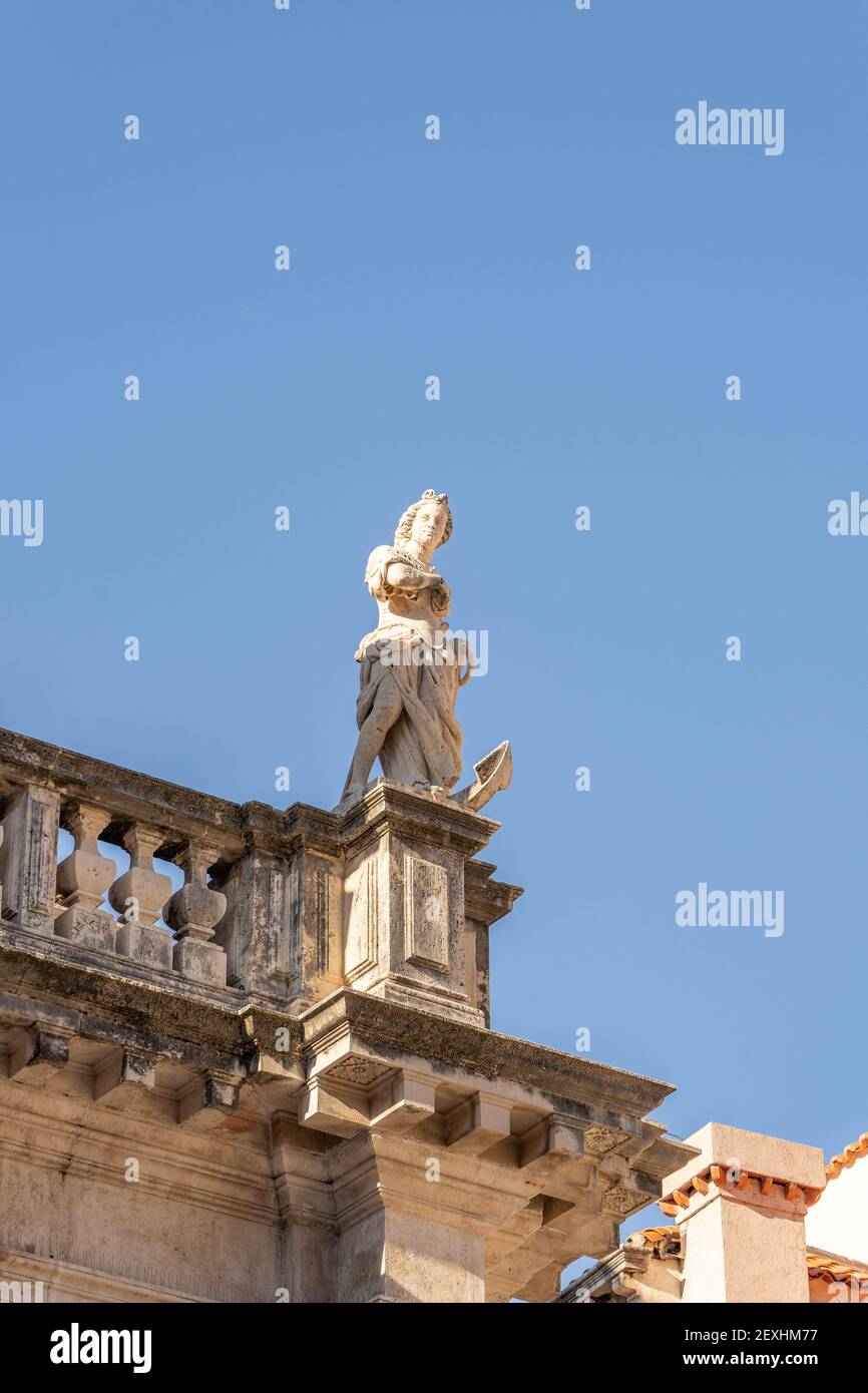 Statua in marmo della dea in cima all'edificio di stradun strada nel centro storico di Dubrovnik in estate mattina Foto Stock