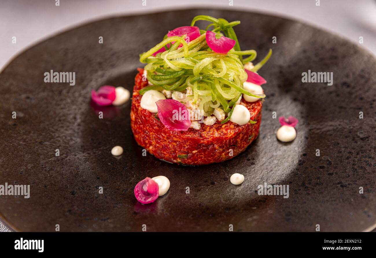 Tartare di bistecca servito con tagliatelle di cetrioli e cipolla marinata sottaceto Foto Stock