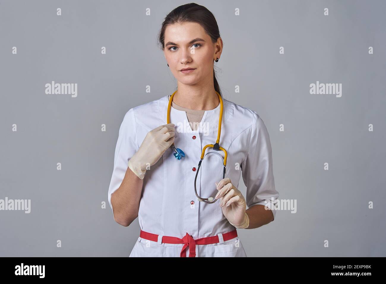 giovane medico in camice bianco con uno stetoscopio giallo intorno il collo Foto Stock