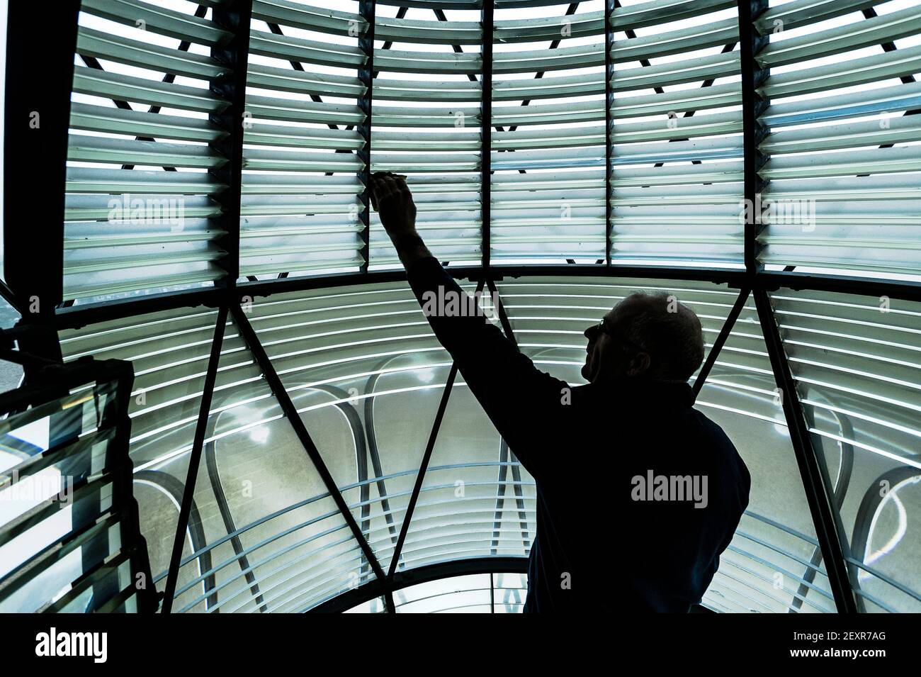 Faro di Happisburgh, Norfolk, 6 febbraio 2021 Patrick Tubby, presidente di Happisburgh Lighthouse Trust pulizia della lampada da 500 w, e i prismi di vetro che sono originali datati dal 1860 all'interno della lente Fresnel. Il faro di Happisburgh sulla costa nord del Norfolk è l'unico faro gestito in modo indipendente in Gran Bretagna. E' anche il più antico faro funzionante dell'Anglia Orientale. Fotografia di Jason Bye t: 07966 173 930 e: mail@jasonbye.com w: http://www.jasonbye.com Foto Stock