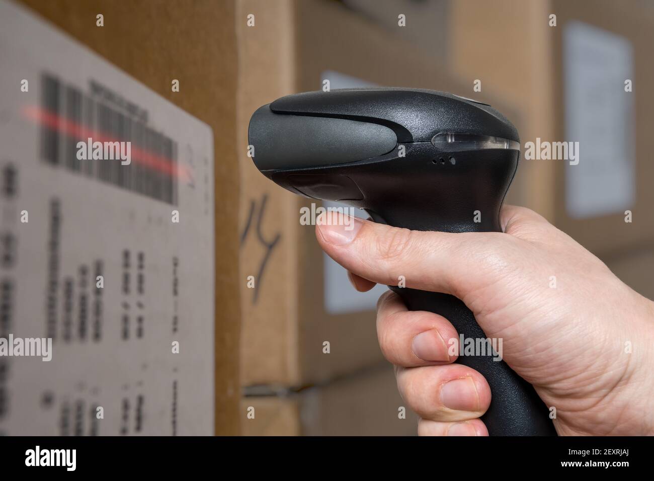 Scansione di codici a barre con lettore di codici a barre su confezioni in magazzino. Foto Stock