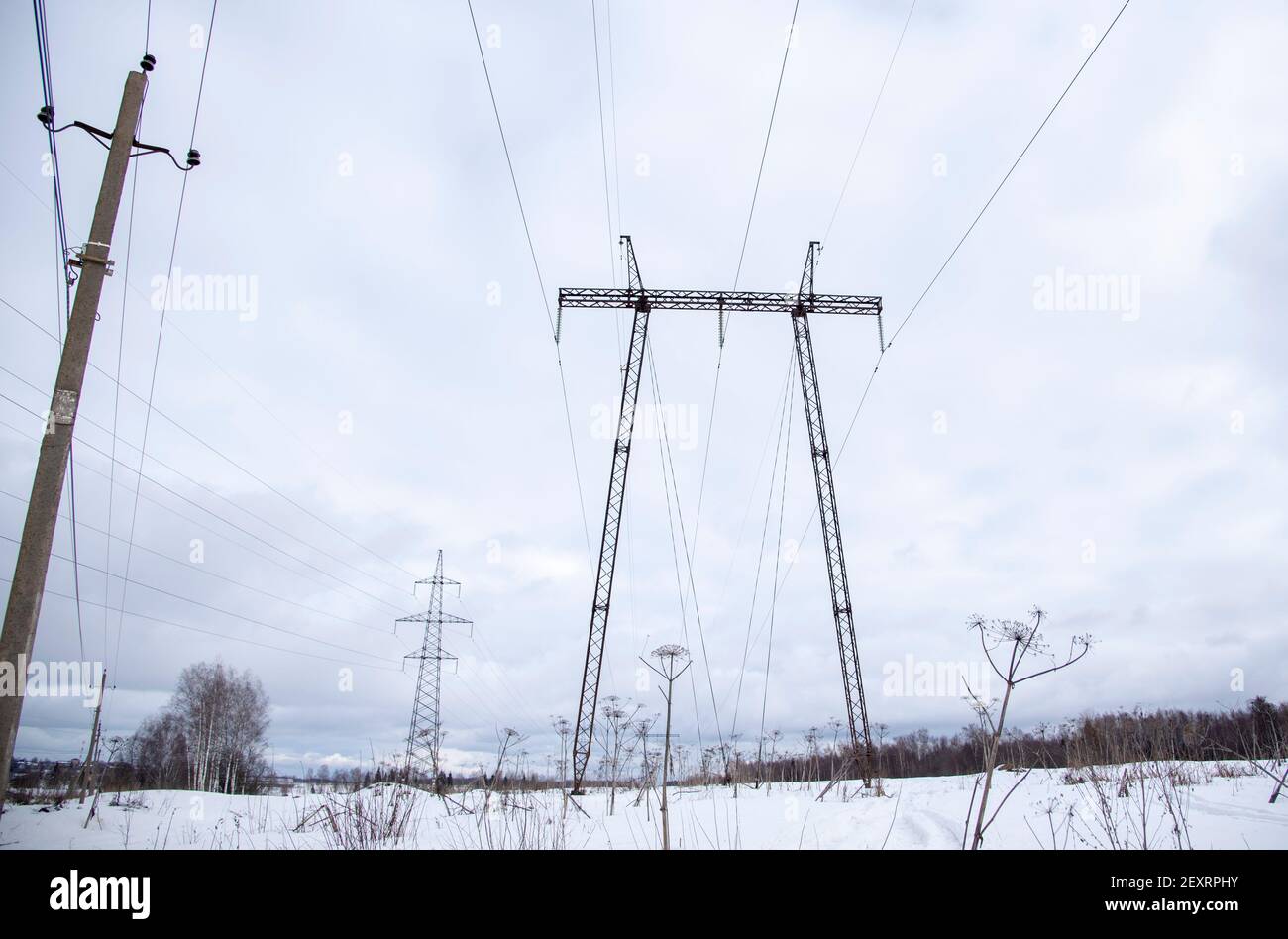 Una linea di alimentazione ad alta tensione contro un cielo nuvoloso. Montanti della linea elettrica. Foto Stock