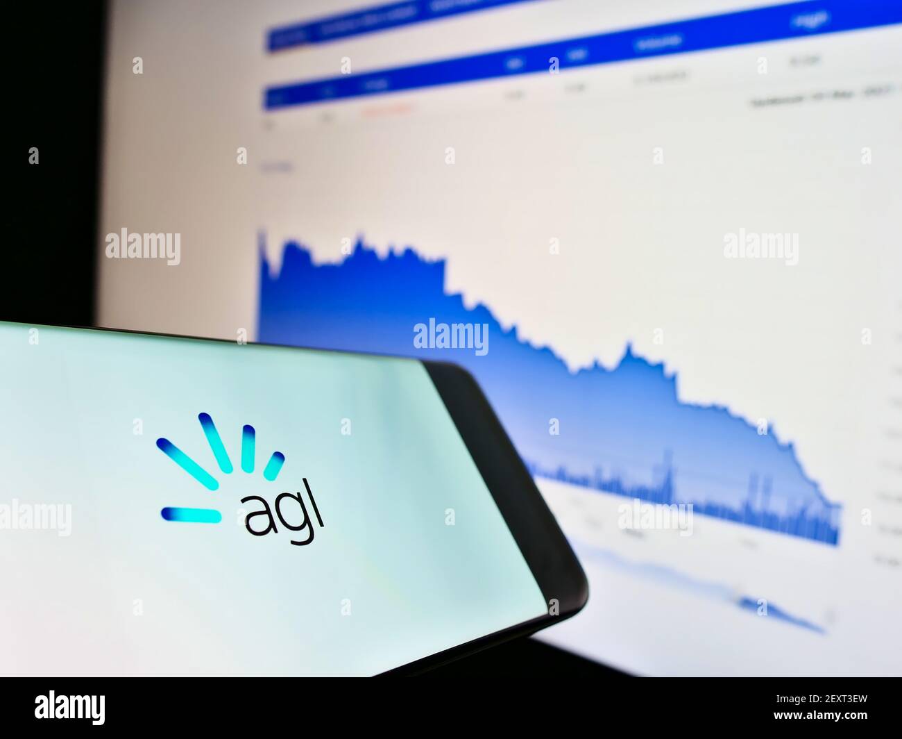 Telefono cellulare con logo della società di servizi australiana AGL Energy Limited sullo schermo di fronte al sito web con grafico. Mettere a fuoco il centro del display del telefono. Foto Stock