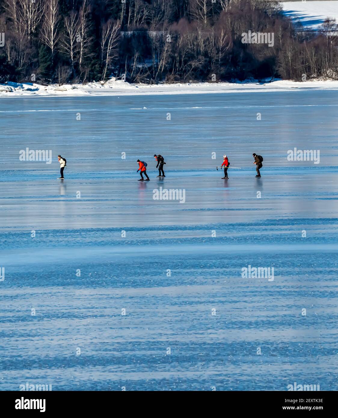 Gruppo di persone che pattinano sul ghiaccio chiaro su un mare ghiacciato. Foto Stock