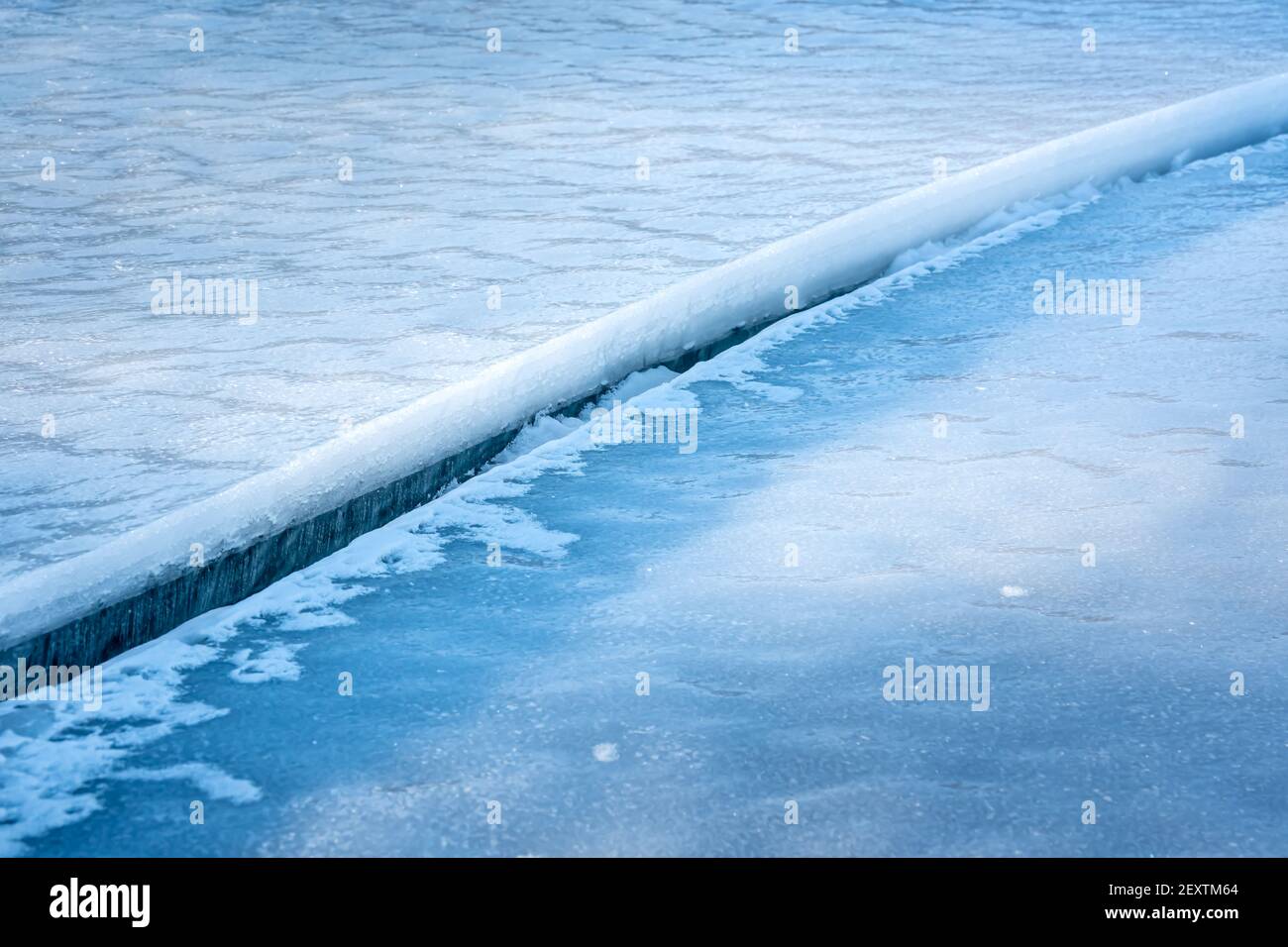 Grande spaccatura pulita in ghiaccio di mare con neve bianca sulla parte superiore. Foto Stock