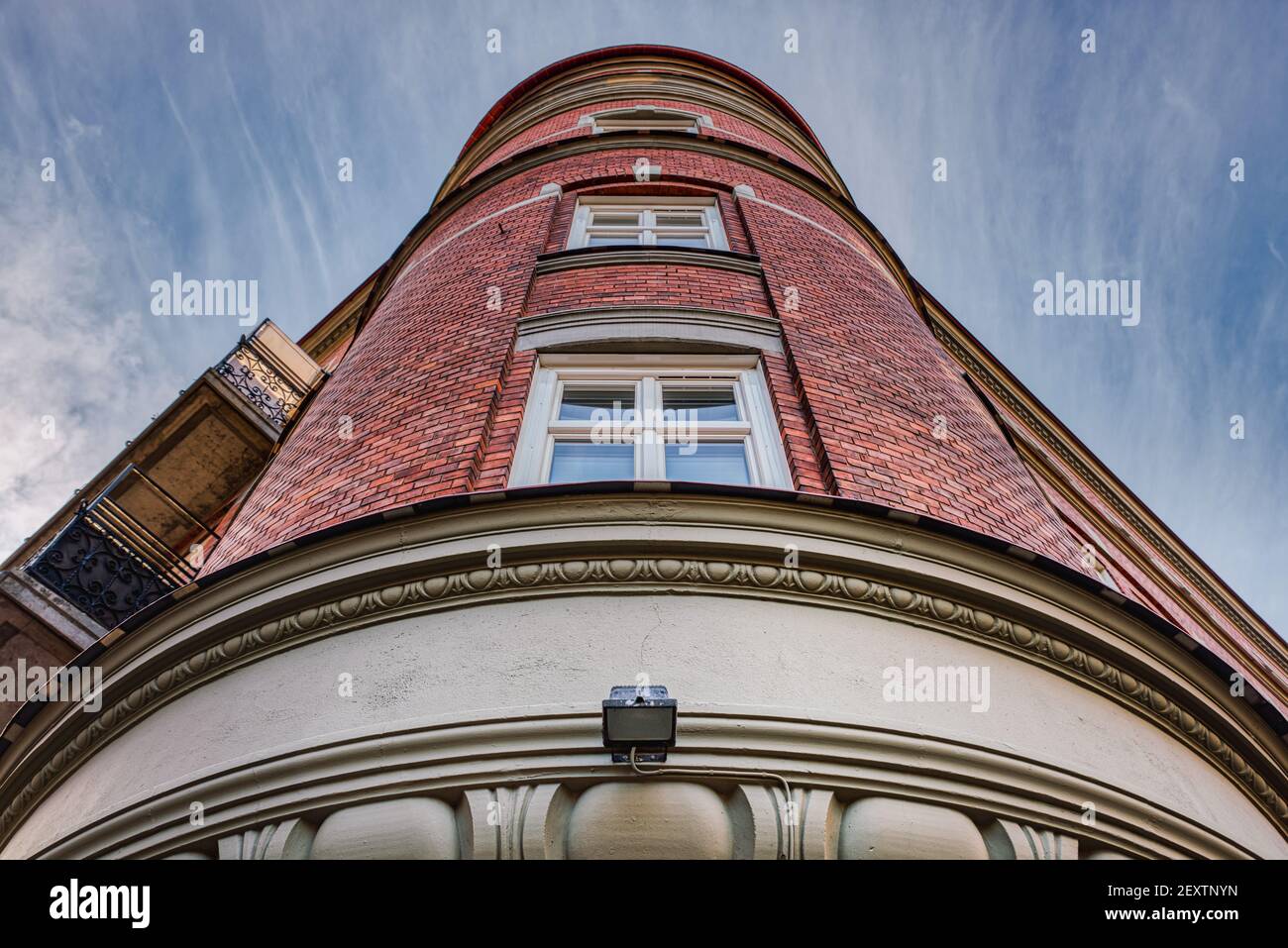 Facciata cilindrica classica in mattoni con finestre al centro. Edificio neoclassico o arrotondato con esterno in mattoni rossi Foto Stock