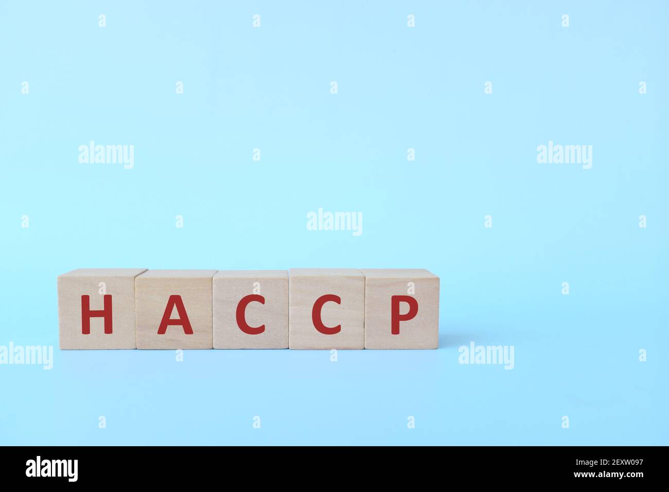 Acronimo HACCP in blocchi di legno su sfondo blu. Sicurezza nell'industria alimentare e nel concetto di produzione. Foto Stock