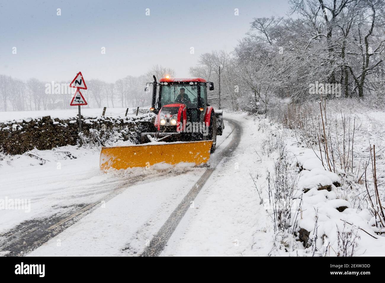 Trattore con spazzaneve che srade l'A684 dopo una nevicata pesante, Hawes, North Yorkshire, Regno Unito. Foto Stock