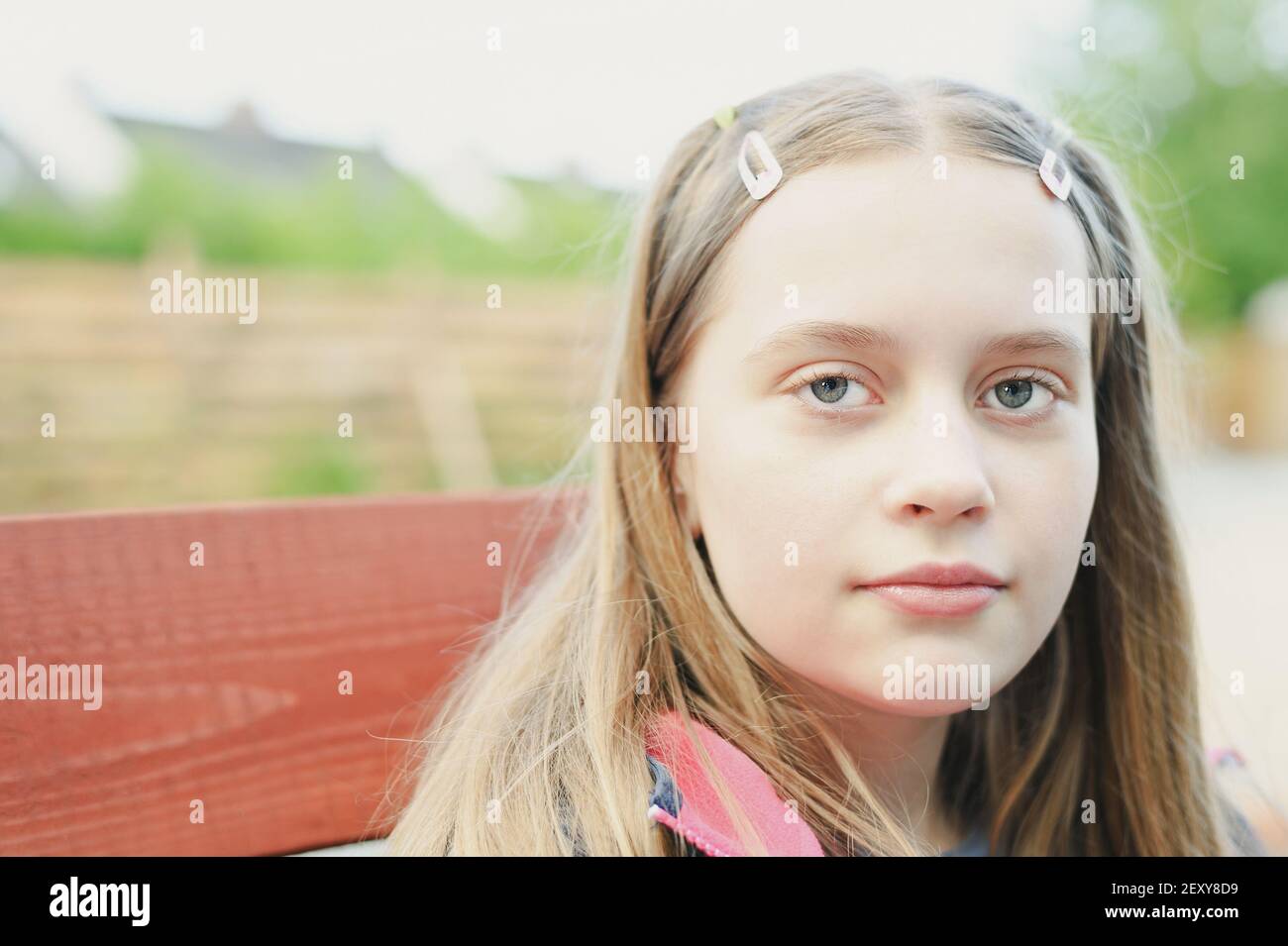 Ritratto di cute ragazza adolescente capelli biondi guardando la macchina fotografica, primo piano con sfondo sfocato Foto Stock