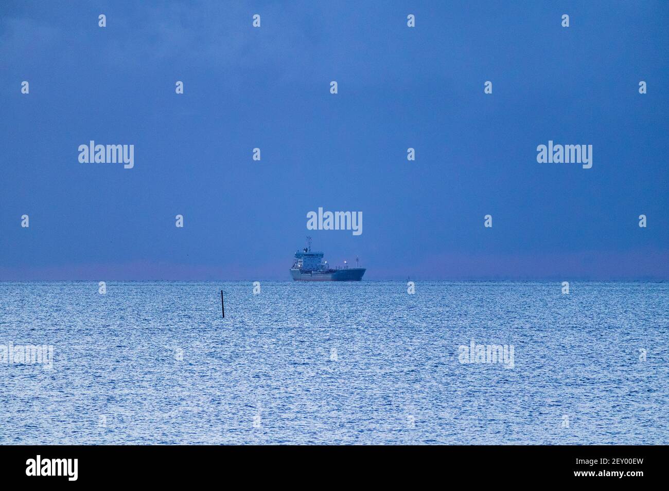 Spedire ad Anchor nell'estuario del Tamigi come Day Breaks ON Una mattina fredda e chiara di marzo Foto Stock