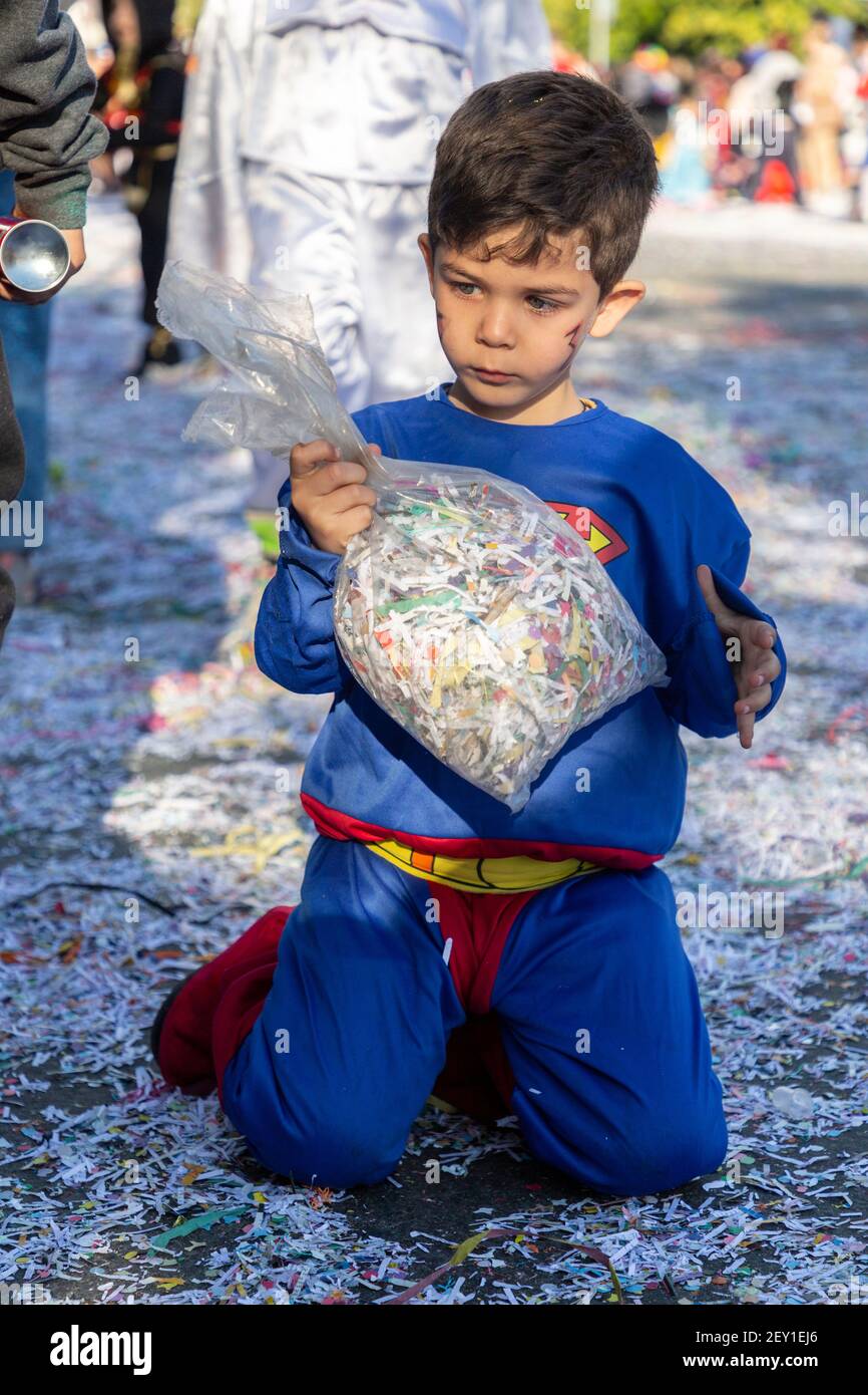 Ritratto di un ragazzo in costume superman che tiene una borsa di confetti  in strada durante il Carnevale di Limassol, Cipro, 1 marzo 2020 Foto stock  - Alamy