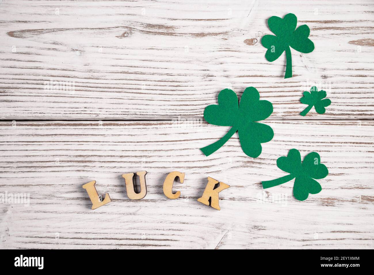 Parola fortuna e foglie di trifoglio di shamrock su sfondo bianco di legno. Buon giorno di San Patrizio. Vacanza irlandese. Posiziona per il testo. Foto Stock