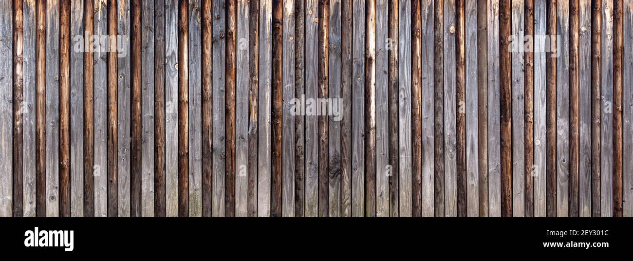 Parete in legno in tavole verticali con legno rotondo attaccato Foto Stock Parete in legno in tavole verticali con legno rotondo attaccato Foto Stock