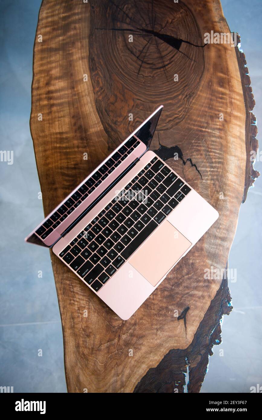 Laptop rosa su un lussuoso tavolo in legno Foto Stock
