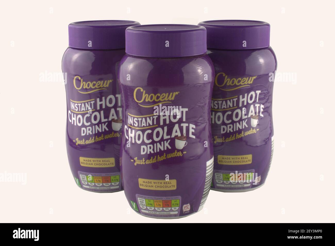 Bevanda calda istantanea al cioccolato in vasetti di plastica viola isolati su sfondo bianco con spazio copia Foto Stock