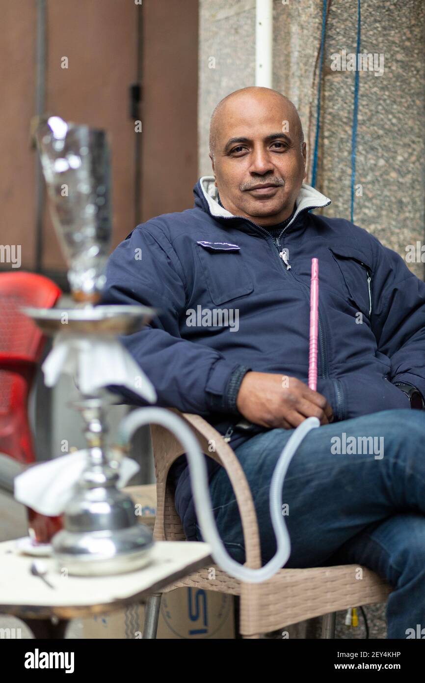 Ritratto di un uomo egiziano locale che fuma una pipa di shisha in un caffè (ahwa) nel centro del Cairo, Egitto Foto Stock