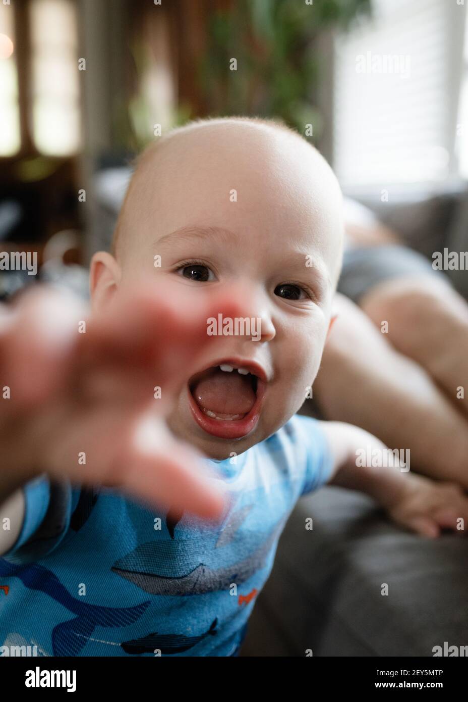 Il bambino è in grado di raggiungere il telefono con fotocamera in soggiorno Foto Stock