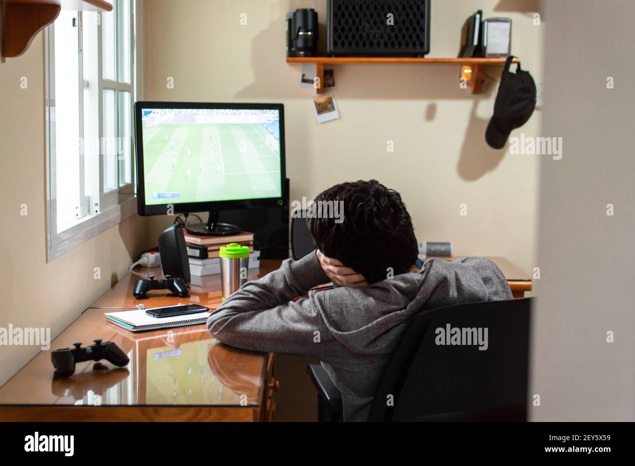 Annoiò un uomo seduto in camera guardando una partita di calcio in televisione. Foto Stock
