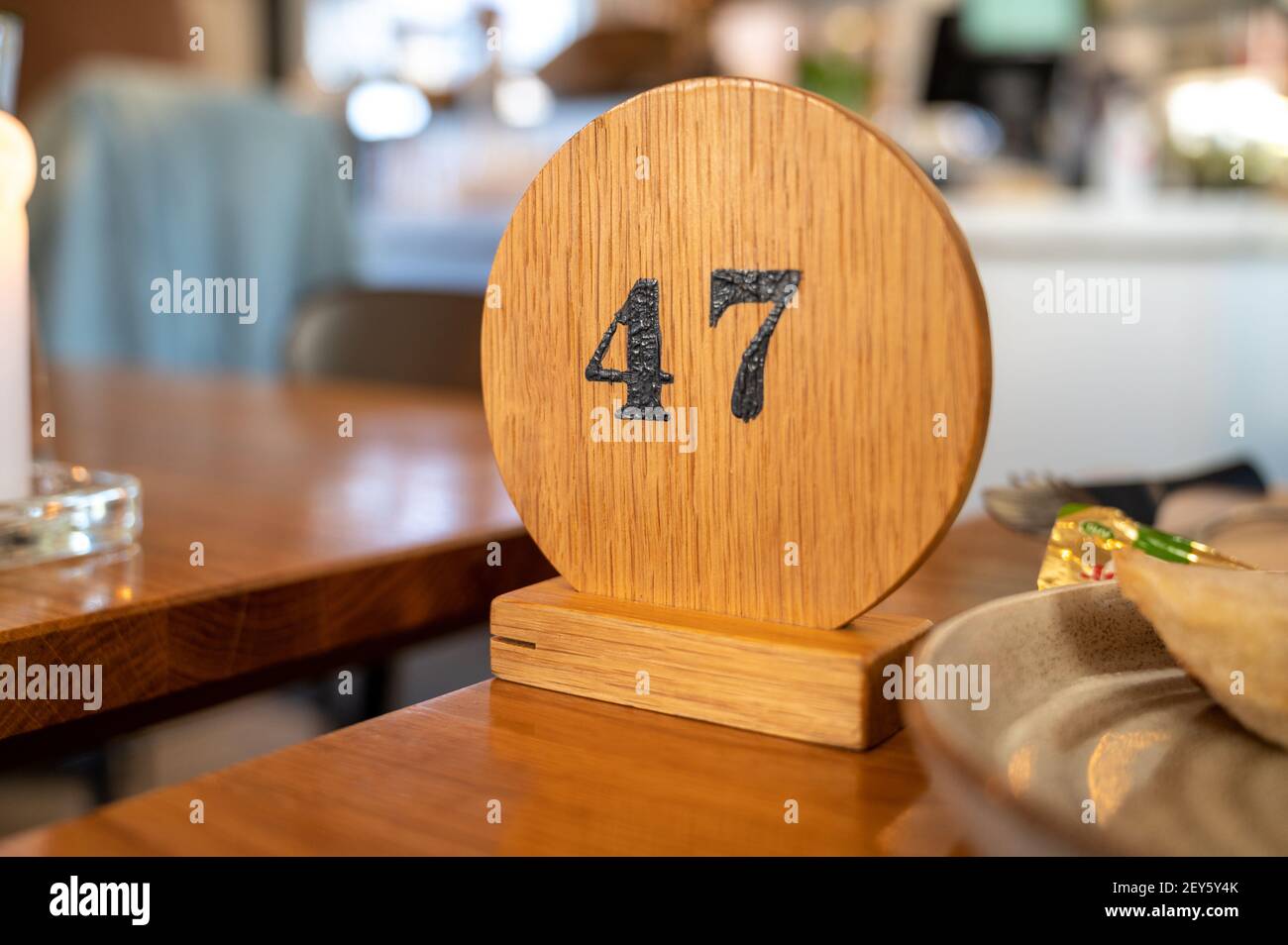 Un cartello in legno con il numero 47 che segna la coda dei visitatori numero in attesa di cibo come parte di nuovo normale a. Ristoranti dopo Covid-19 Foto Stock